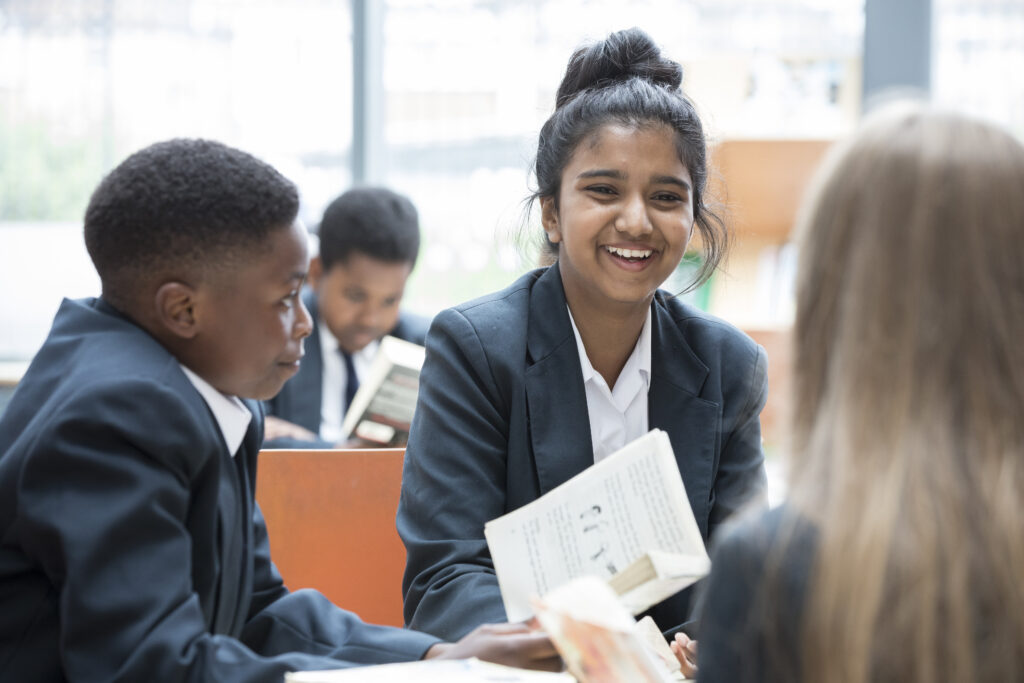 Students are laughing while talking during their lunch break.